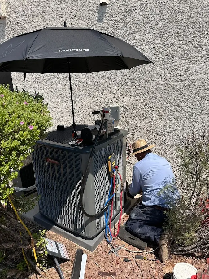 HVAC technician performing outdoor AC maintenance in Big Bear City