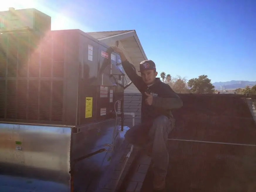 HVAC technician performing Air Duct Cleaning on a rooftop unit in Big Bear City